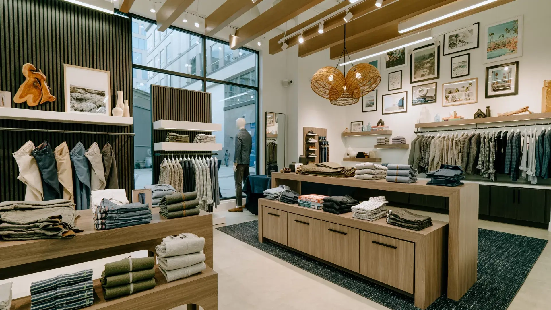 Inside a Johnnie-O store: oak tables of folded sweaters, shelves of shirts and a woven pendant lamp